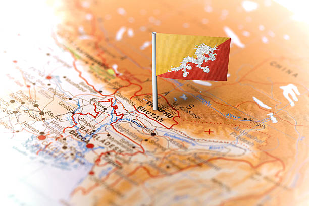 The flag of Bhutan pinned on the map. Horizontal orientation. Macro photography.
