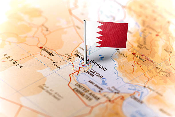The flag of Bahrain pinned on the map. Horizontal orientation. Macro photography.