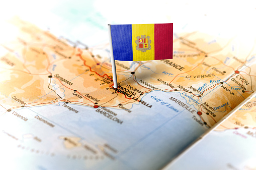 The flag of Andorra pinned on the map. Horizontal orientation. Macro photography.