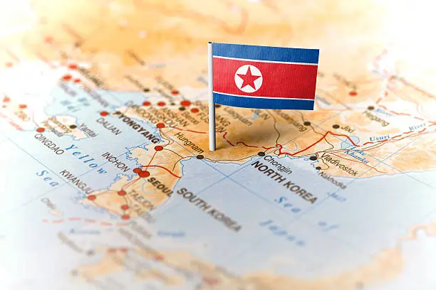 The flag of North Korea pinned on the map. Horizontal orientation. Macro photography.