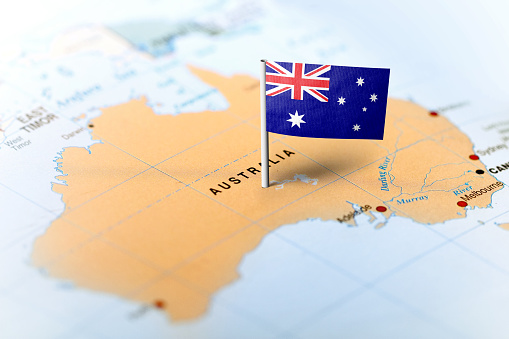 The flag of Australia pinned on the map. Horizontal orientation. Macro photography.