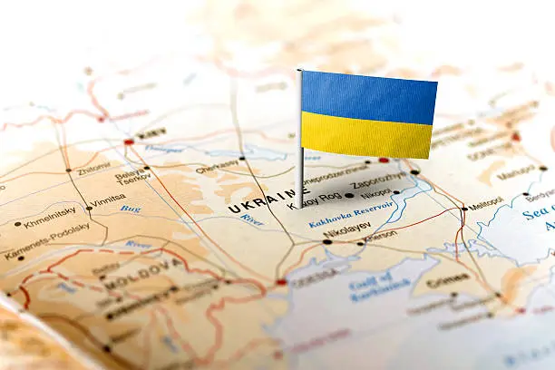 The flag of Ukraine pinned on the map. Horizontal orientation. Macro photography.