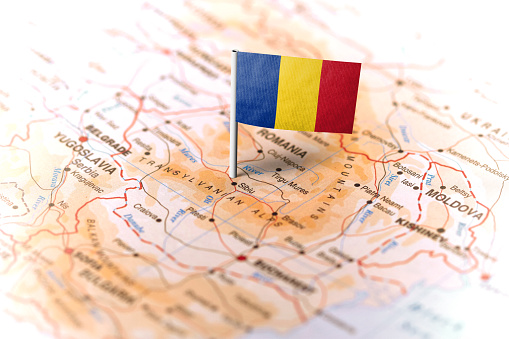 The flag of Romania pinned on the map. Horizontal orientation. Macro photography.