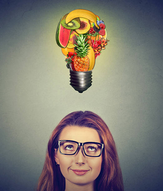 istock Woman looking up at fruits light bulb 583800682