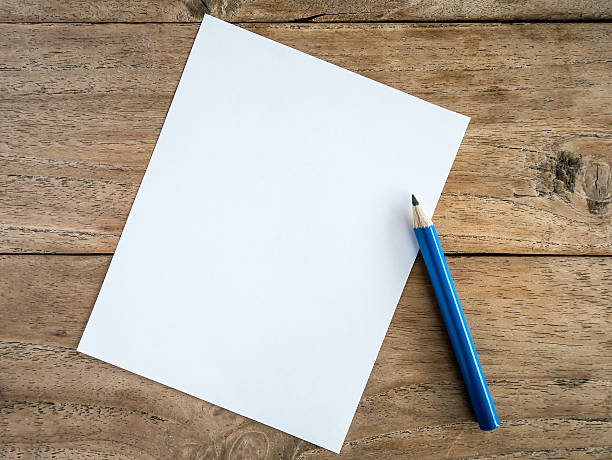 istock Blank paper with pencil on wood table 583802264