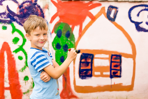 Children drawing on the wall depict the house in the summer outdoorsChildren drawing on the wall depict the house in the summer outdoors