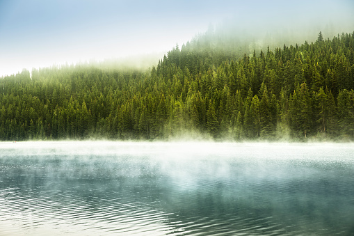 Mist rises over Lake Minnewanka in Banff National Park Alberta Canada