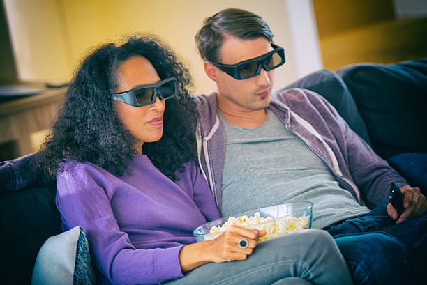 istock Young couple watching a movie with 3D glasses 583808034