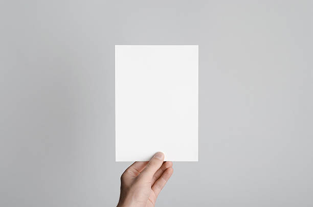 A5 Flyer / Postcard / Invitation Mock-Up Male hands holding a blank flyer on a gray background. holding photos stock pictures, royalty-free photos & images