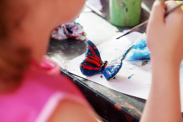 istock Girl paints a butterfly 583812476