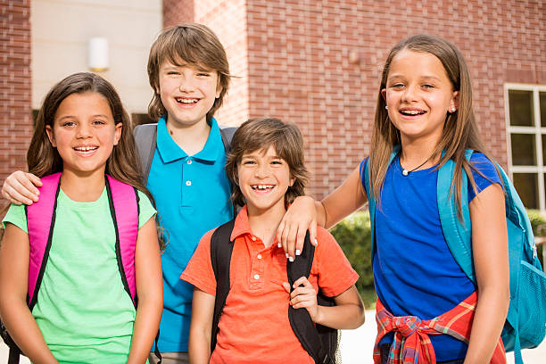 istock Elementary-age children, friends on school campus going back to school. 583813368