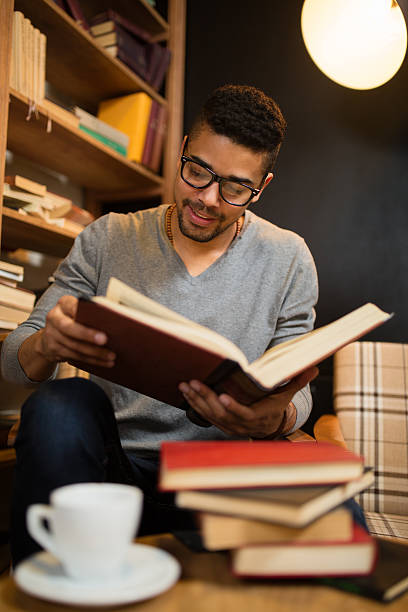 istock Smiling African American student  enjoying book reading in library. 583815246