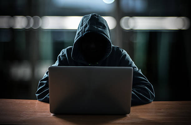 Hacker in front of his computer Hacker in front of his computer. Dark face computer hacker stock pictures, royalty-free photos & images