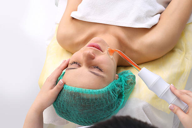 istock Receiving electric darsonval facial massage procedure. 583818994