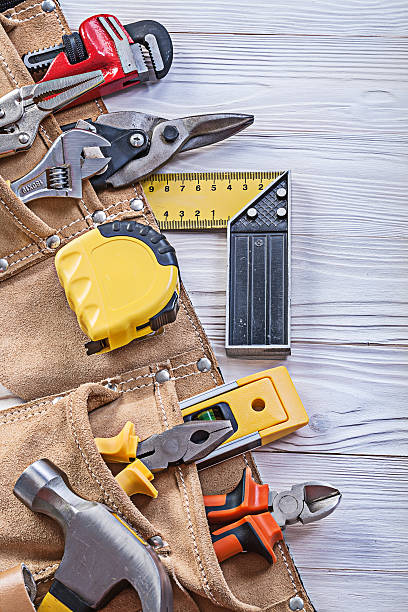 istock Construction tooling in tool belt on wooden board maintenance co 583829132