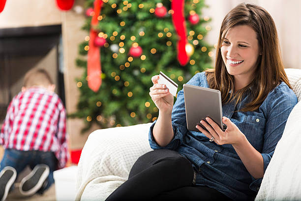 frau nutzt digitales tablet, um zu weihnachten online einzukaufen - christmas shopping internet family stock-fotos und bilder