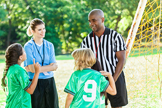 istock Youth soccer coach and referee talk with players 583831572