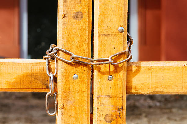 istock Wooden field gate closed detail with chain 583833484