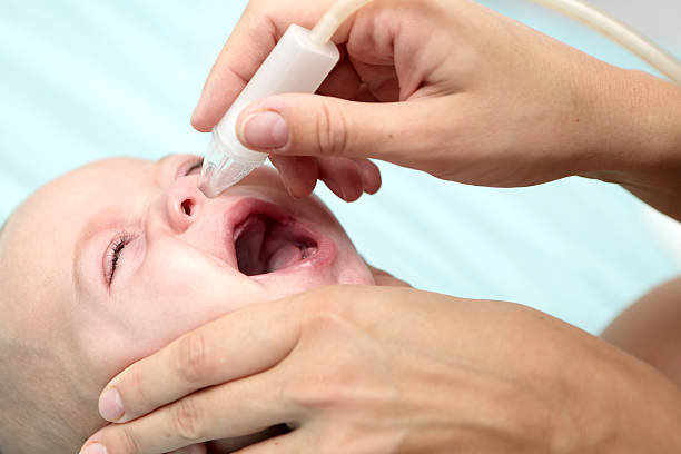 istock Mother using child's nasal aspirator 583838766