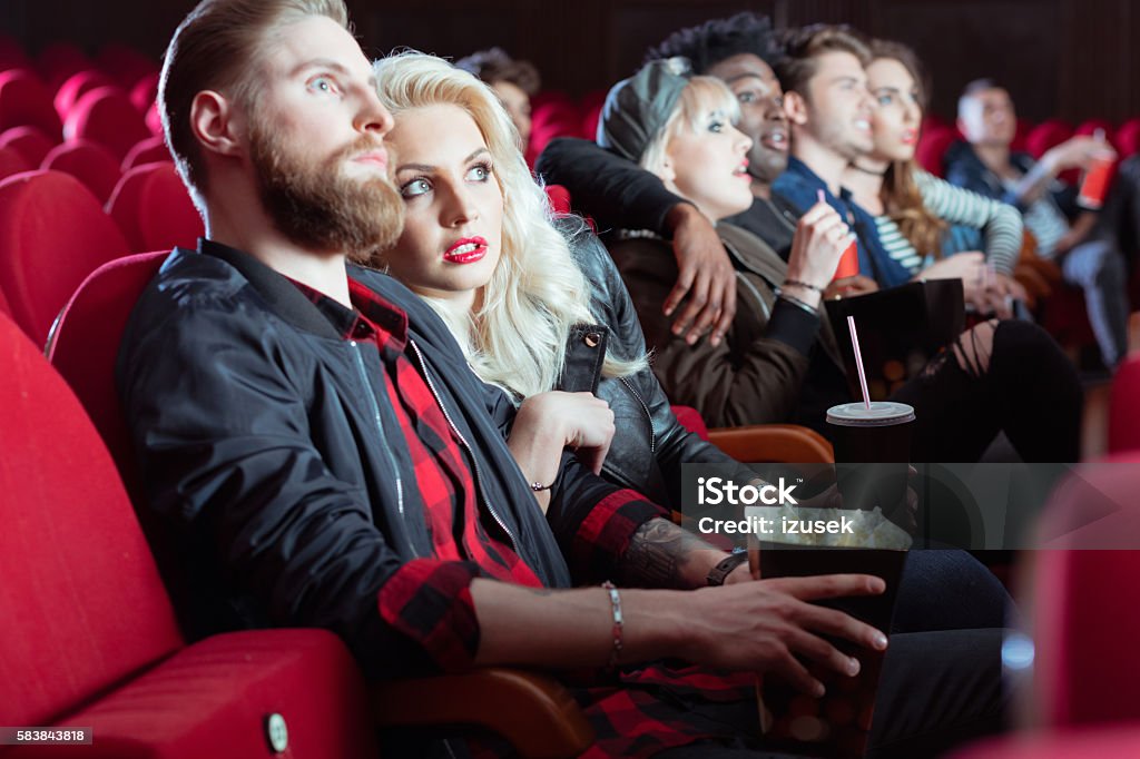 Young people in 3D movie theater Multi ethnic group of young adult people watching scary movie in the cinema.  Audience Stock Photo