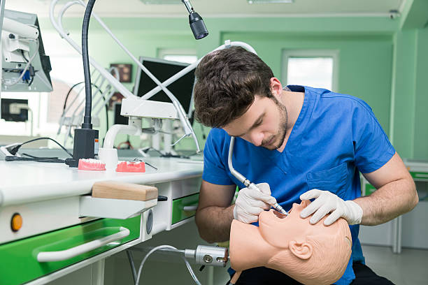 istock Male dental student practicing on doll. 583847860