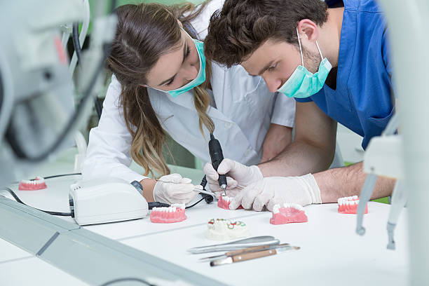 Dental prosthesis, dentures, prosthetics work. Dental prosthesis, dentures, prosthetics work. Prosthetics hands while working on the denture, false teeth, a study and a table with dental tools. human teeth stock pictures, royalty-free photos & images