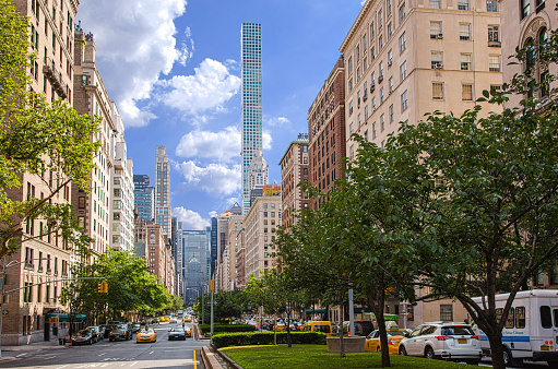 New York, NY, USA - June 29, 2016: Park Avenue, Manhattan Upper East Side, New York City. Residential highrises (cooperatives and condominiums), street, road, sidewalk, cars, green grass and trees and blue sky with clouds are in the image. Canon EOS 6D (Full Frame censor) and Canon EF 24-105mm f/4L IS lens. Circular polarizer.  HDR photorealistic image.