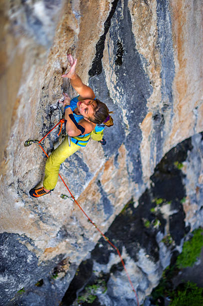istock Girl climber climbs on rock. 583850134
