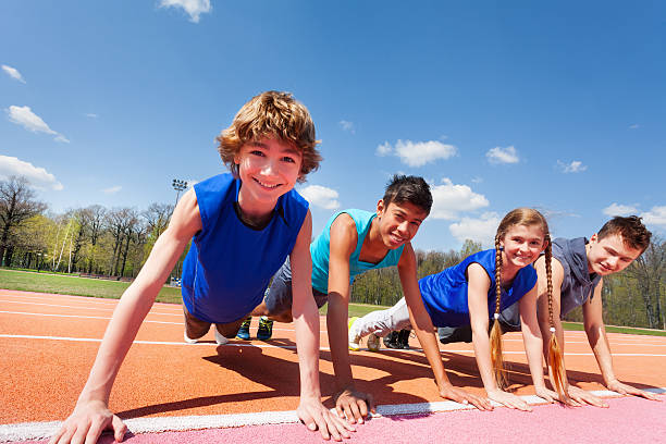 happy teenagers holding plank outdoor on the track - school sports imagens e fotografias de stock