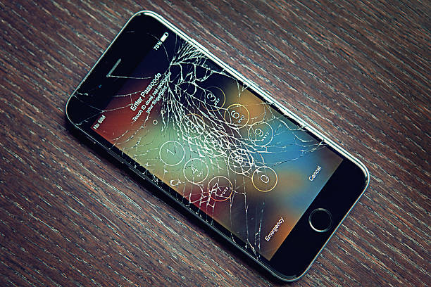 Broken Iphone 6 Sofia, Bulgaria - May 15, 2015: Broken Iphone 6 still working. On the photo is my 12 years old daughter`s Iphone 6, broken after she fell down from her bicycle. The phone screen is crashed but the phone was still working. The image was taken at the 15th of May 2015 at the same day when she fell down from her bicycle and broke her Iphone. The image was taken in the our home in Sofia, Bulgaria. desk toy stock pictures, royalty-free photos & images