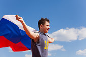 Portrait of teenage boy running with Russian flag
