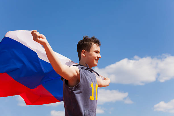 Portrait of teenage boy running with Russian flag stock photo