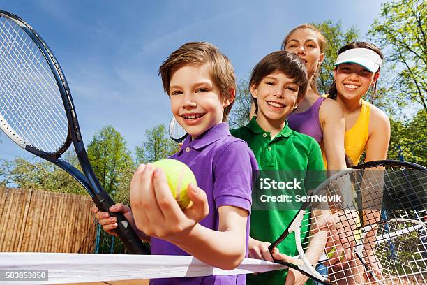 Family Playing Tennis Holding Rackets And Ball Stock Photo - Download Image Now - Tennis, Child, Teenager