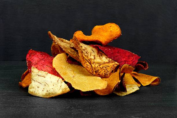 Pile of vegetable chips on a black background