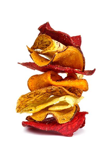 Stack of vegetable chips isolated on white Stack of mixed healthy vegetable chips isolated on a white background root vegetable stock pictures, royalty-free photos & images