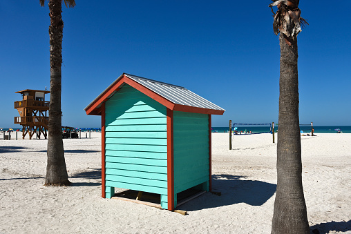 A colorful beach bath house on the sandy public beach area