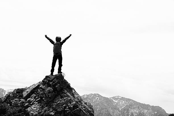 istock cheering successful woman backpacker open arms on mountain peak 583857488