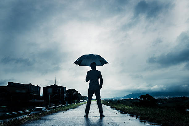 istock businessman are holding an umbrella, dark image 583861648