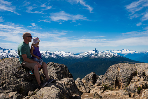 Father and daughter enjoying a stunning mountain backdrop in British Columbia's Coast Mountain Range