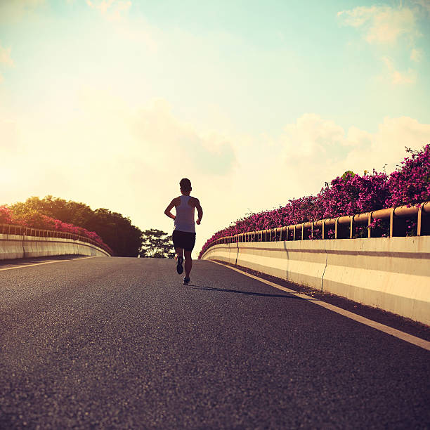 istock young woman runner running on city bridge road 583958836