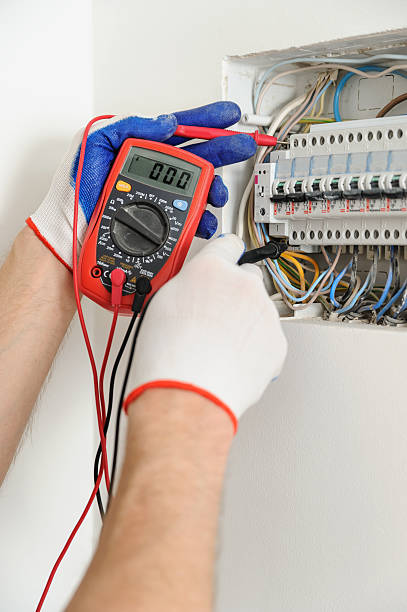 istock Electrician check voltage in electrical fuse box. 583959154