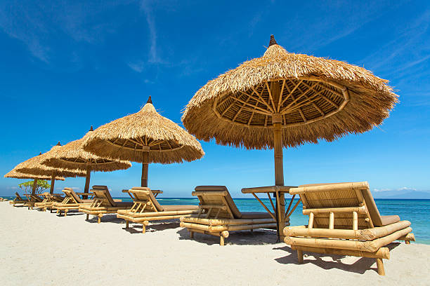 istock Beach chairs with straw umbrellas on a beautiful tropical beach 583960716