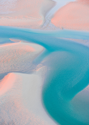 A tidal delta in Australia weaves its way to the sea. Stunning late afternoon colours illuminate the coastal landscape. Aerial image photographed near Broome, Western Australia.