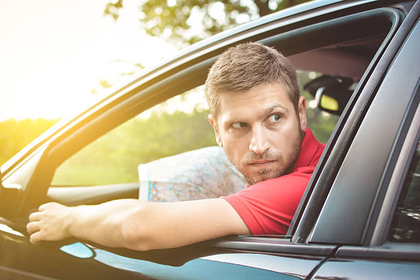 istock Handsome man driver looking back and parking car 583962100