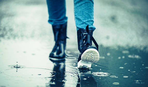 girl in rubber boots outdoors in rainy day - rain women umbrella parasol imagens e fotografias de stock