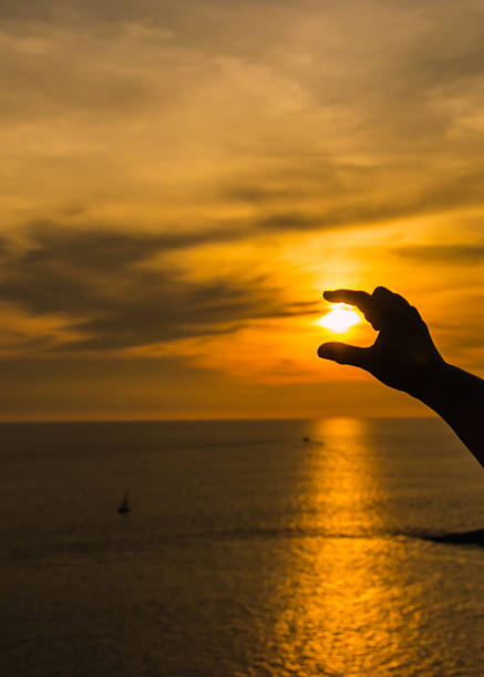 istock hold  sun at sunset over ocean. 583965096