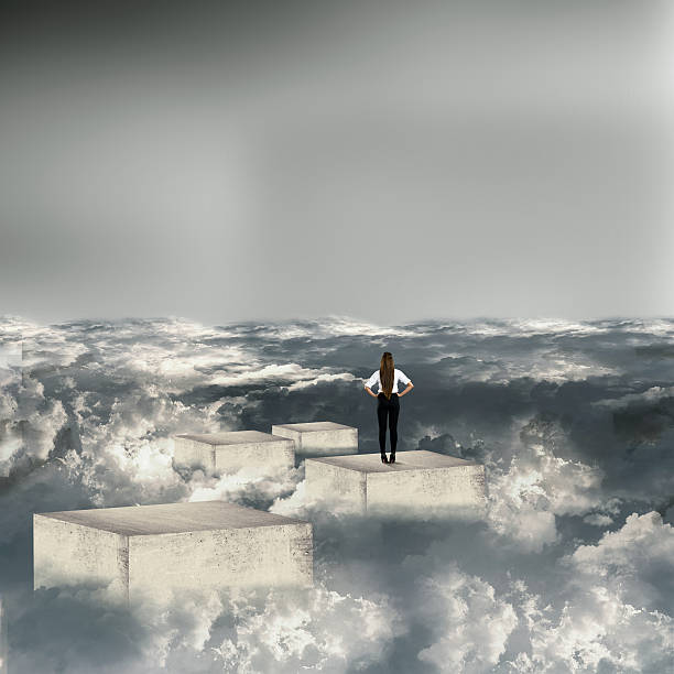 istock Businesswoman standing on concrete blocks above clouds 583966482