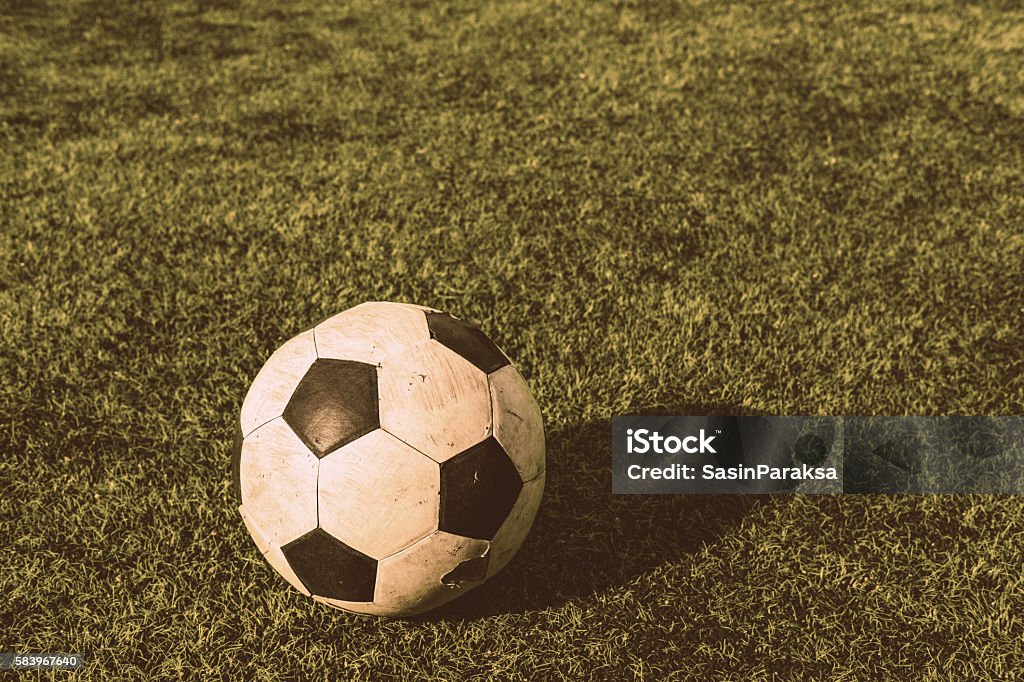 Viejo balón de fútbol sobre césped verde, tono vintage - Foto de stock de Abstracto libre de derechos