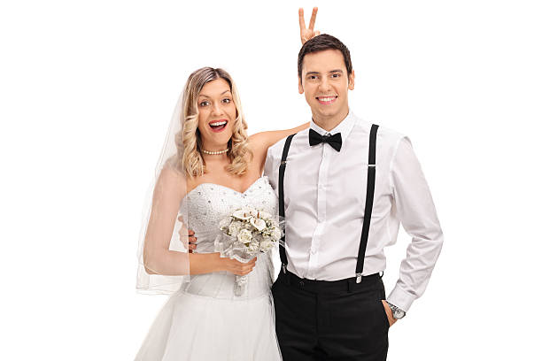istock Bride making bunny ears on the groom 583968176