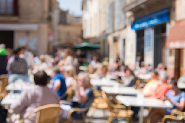 defocused people sitting in summer in a small restaurant outside